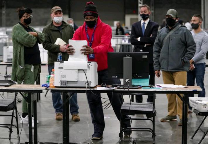 选举工作人员在监票人面前扫描选票
