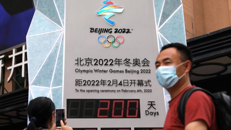 A woman uses her phone in front of a countdown clock showing 200 days to the opening of Beijing 2022 ...