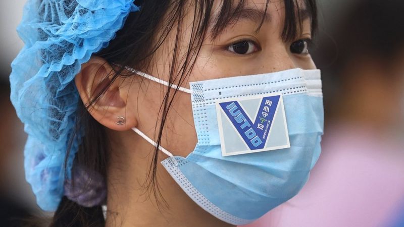 江苏省南京市浦口区一处核酸检测点内志愿者口罩上贴着鼓劲用的贴纸
