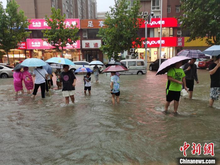 郑州7·20特大暴雨后，市民在街道上趟水而过